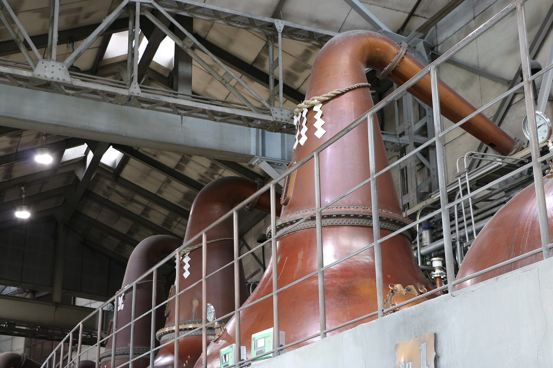余市蒸溜所の蒸留棟に並ぶしめ縄を巻いたポットスチル