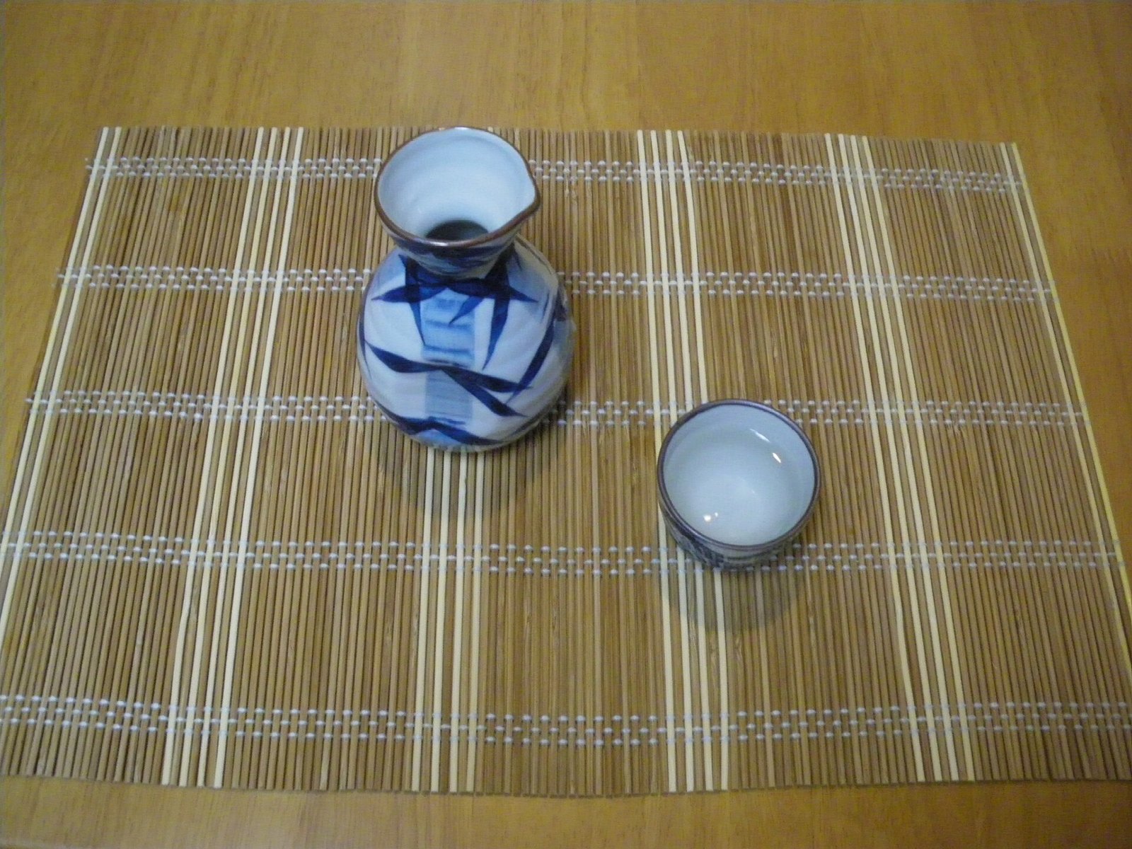 竹のマットに置かれた染付の徳利とぐい呑み