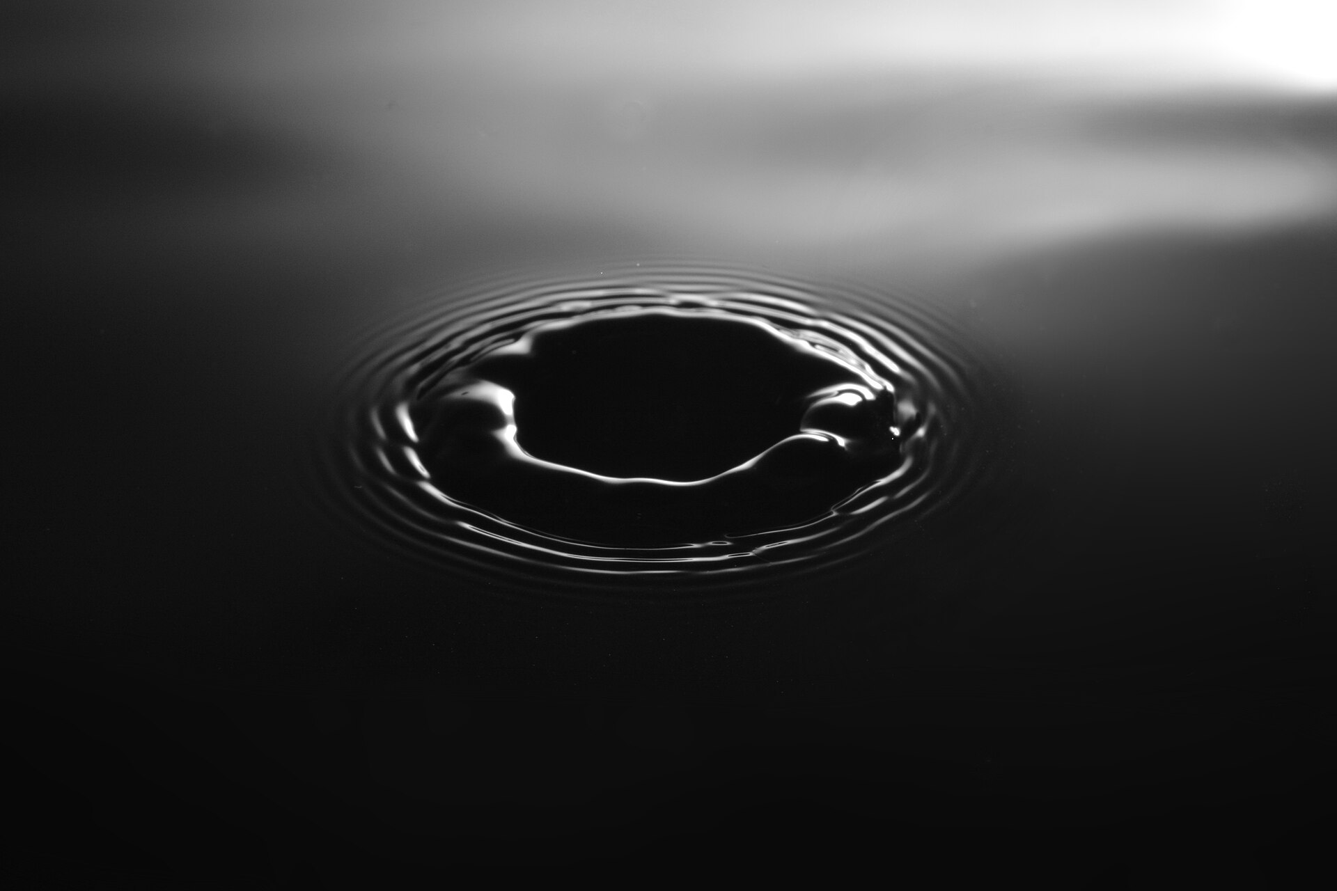 黒い水面に落ちた一滴がつくる波紋（モノクロ）